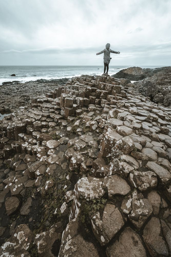 Female standing on cliff and contemplating