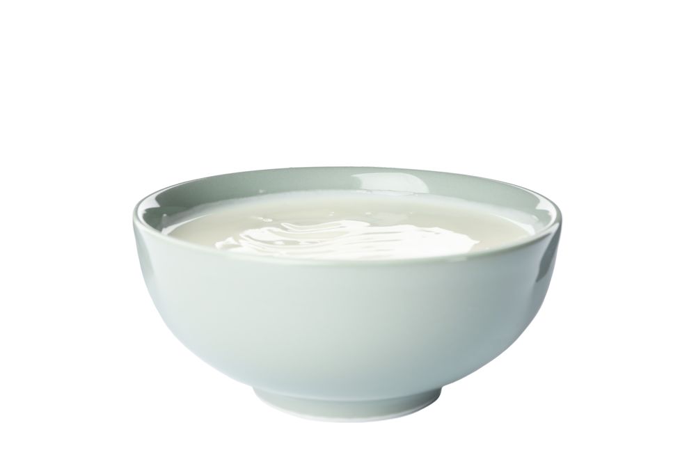 Bowl of sour cream yogurt isolated on light background