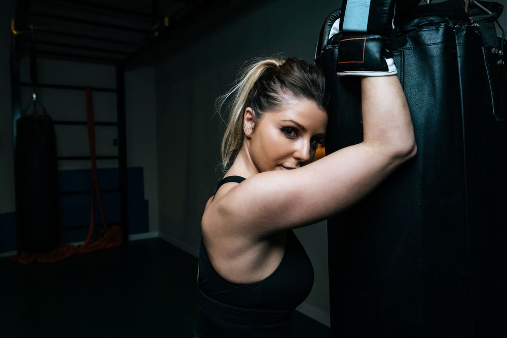 Woman training in gym with punching bag