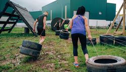 Participants in an obstacle course dragging wheels