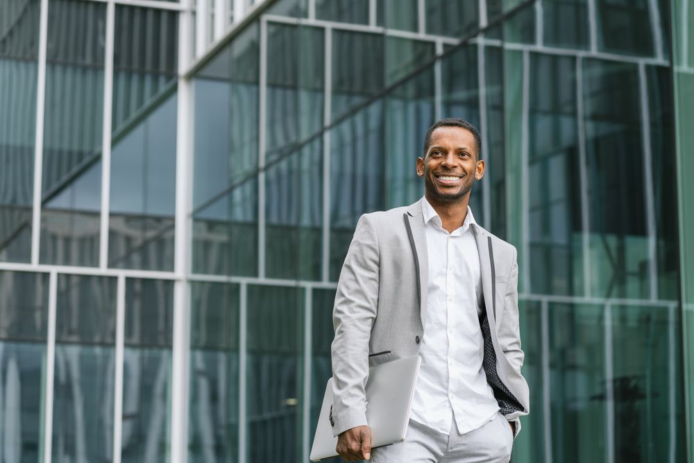 Black man holding laptop on street