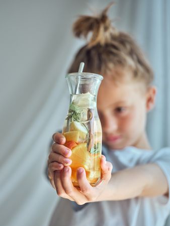 Boy looking down and demonstrating bottle