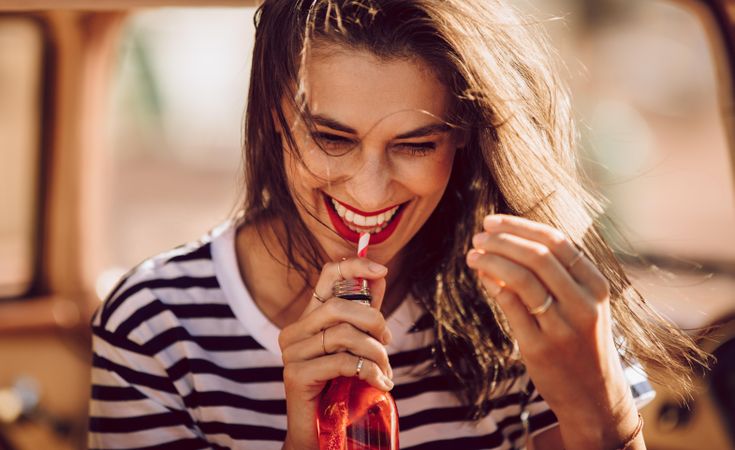 Female drinking refreshing soft drink on a summer day