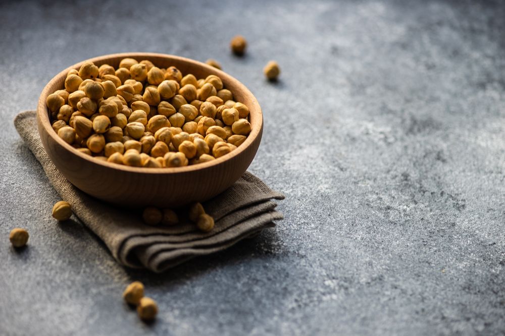 Shelled hazelnuts in bowl on grey counter with copy space