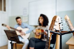 Man and woman playing guitar in studio