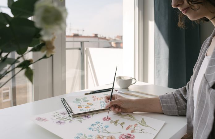 Person drawing flowers with watercolor