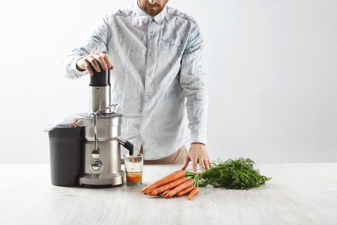 Man with juicer and carrots