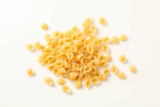 Pasta on bright background, space for text. Dry uncooked whole pasta