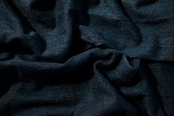 Close up detail crumpled wavy Navy blue jeans fabric background texture.