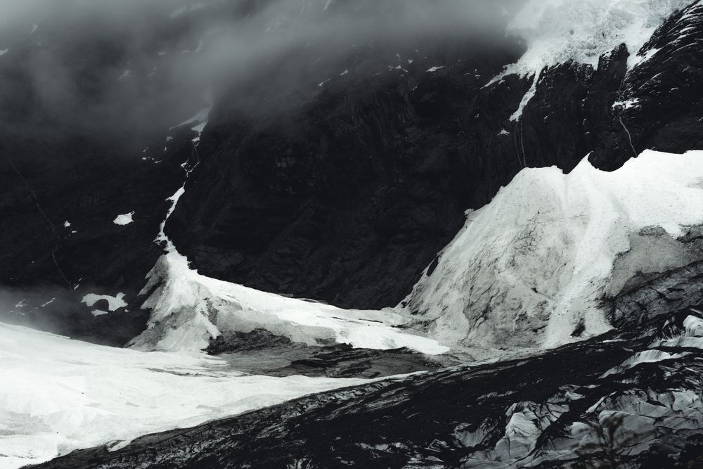 Harsh mountain snowy peak shrouded in fog
