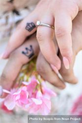 Cropped hands of man and woman with matching King and Queen tattoos bGGVxb