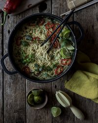 Green curry noodles in pot on table