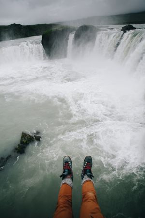 Legs hanging over waterfall