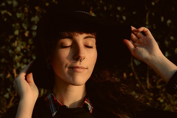 Stylish young woman in felt hat outdoors