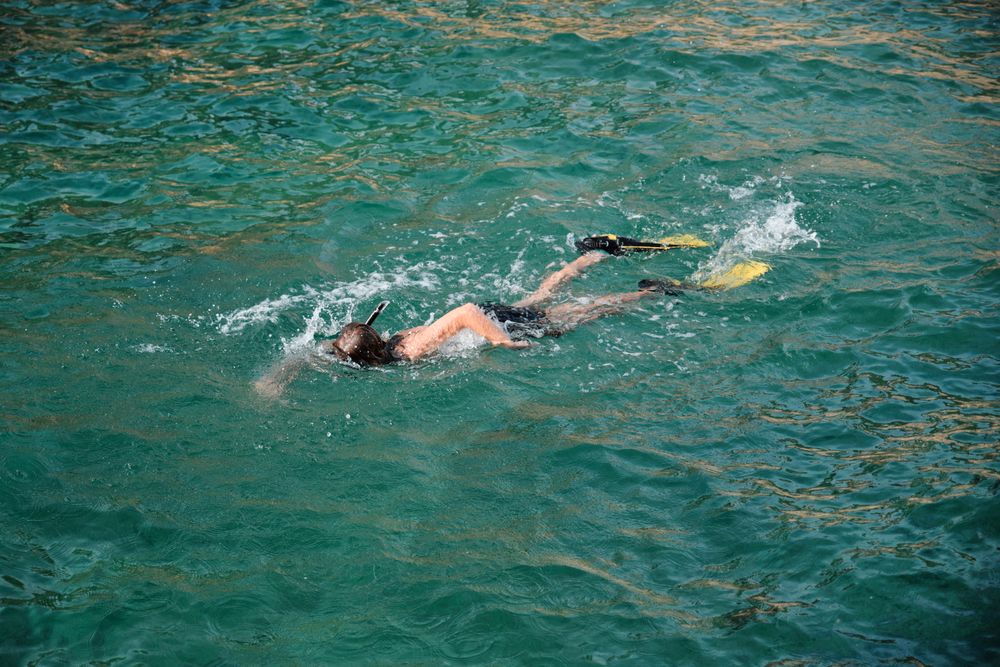 Boy wearing flippers and swimming in sea water