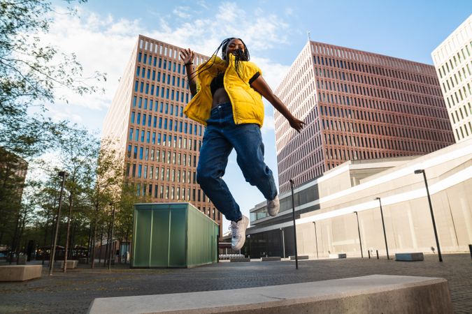 Excited female jumping on city street