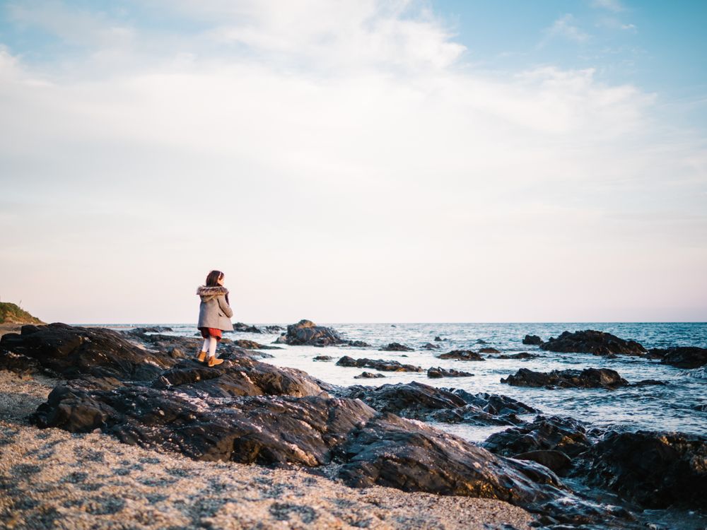 back view of little girl looking at sea