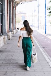 elegant confident businesswoman walking on the street carrying a purse.