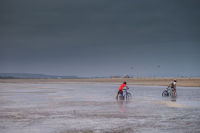 Two boys with bikes in salt marshes, France