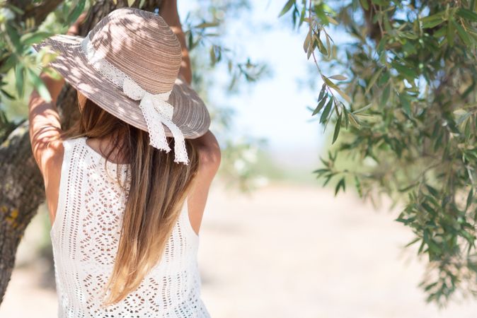 Adult woman standing near tree