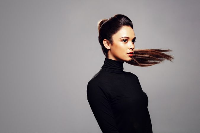 Female fashion model with hair in ponytail flying behind her