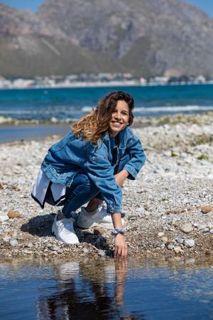Young woman playing with water on shore