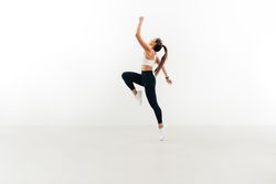 Woman working out with her knee and arm up in bright room