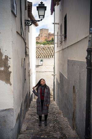 Joyful female tourist in casual wear amid city street