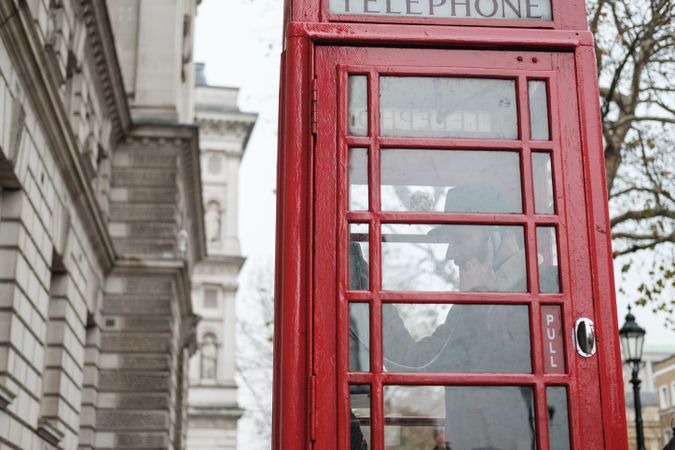 Red telephone box on autumn street