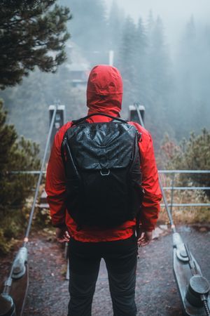 Man in red jacket and backpack standing outdoor