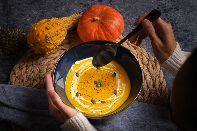 Woman eating tasty pumpkin cream soup