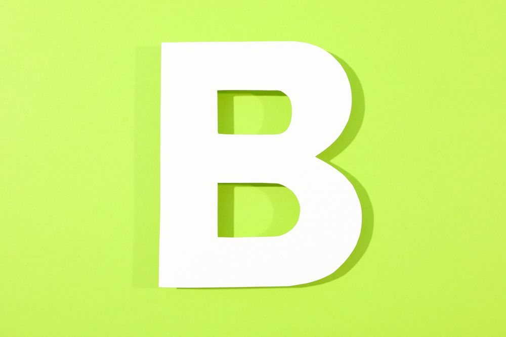 Paper letter B on color background, space for text