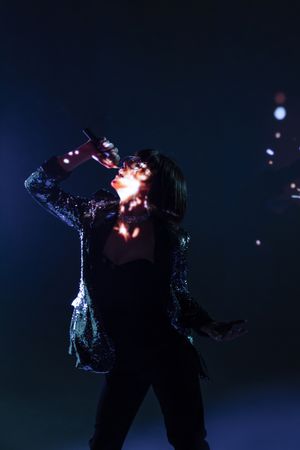 Stylish woman singing on stage