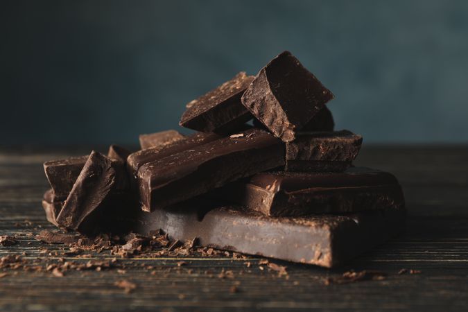 Chocolate pieces on wooden background, close up