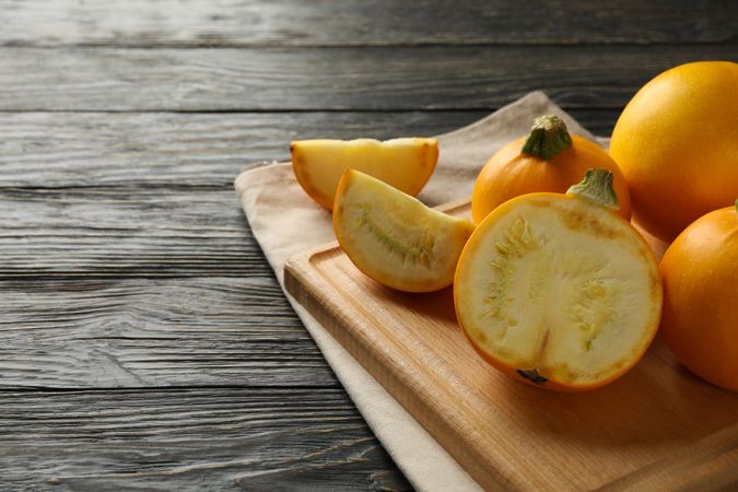 Board with zucchini and napkin on wooden background