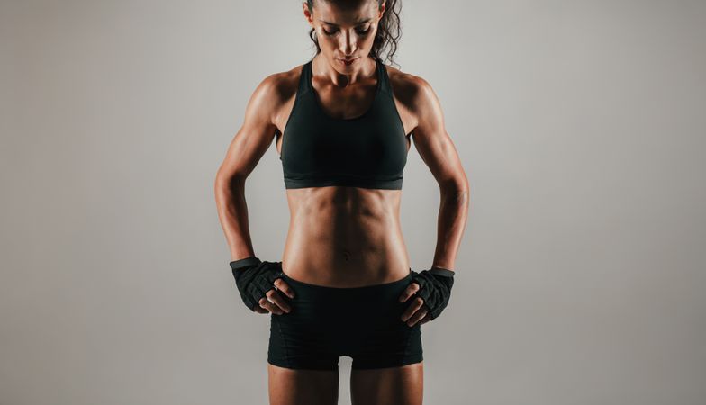Abdominal muscles of woman over gray background