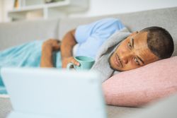 Young man with coronavirus, watching a documentary