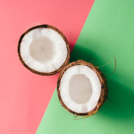 Coconut halves on pink and green background