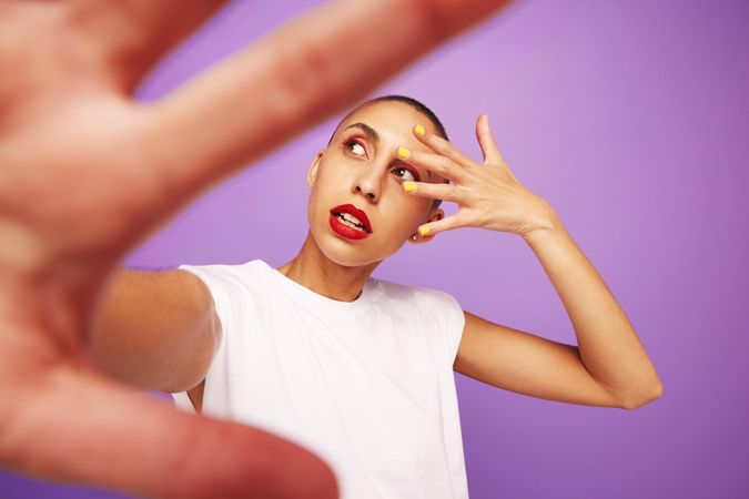 Female model with makeup looking away on purple background
