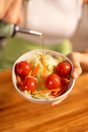 Pouring Olive Oil on Fresh Vegetable Salad - Healthy Eating Lifestyle