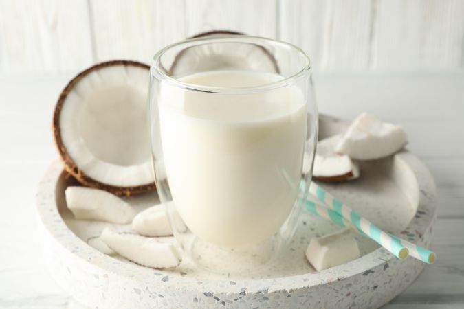 Tray with coconut and milk on wooden background. Tropical fruit