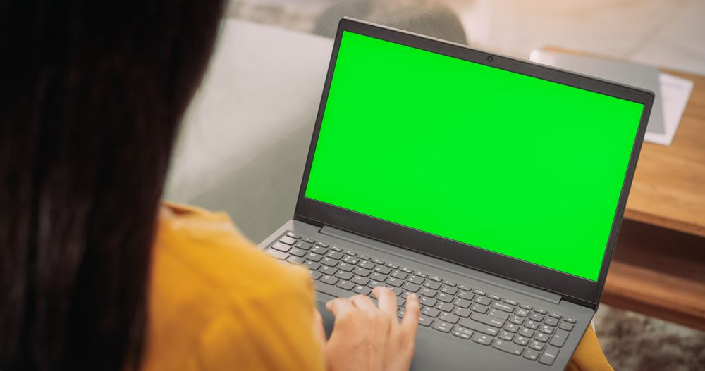 Over-the-Shoulder: Woman Using Laptop with Green Chroma Key Screen