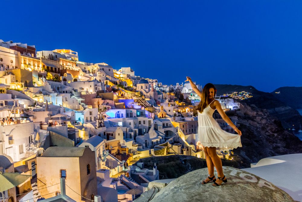 Woman standing near Santorini Greece during nighttime