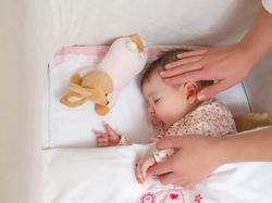 Hands of mother caressing her baby girl sleeping