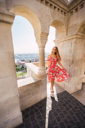 Woman standing near columned marble fence
