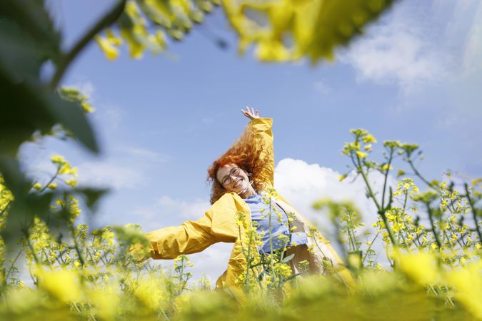 Red haired woman dancing in a yellow field