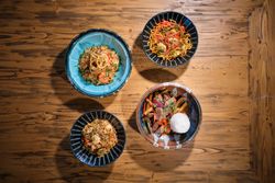 Appetizing dishes served in bowls on wooden table