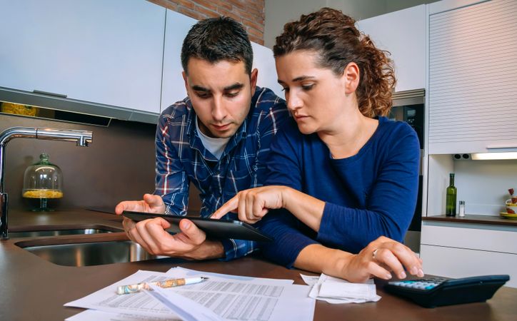 Couple discussing their monthly bills on kitchen counter