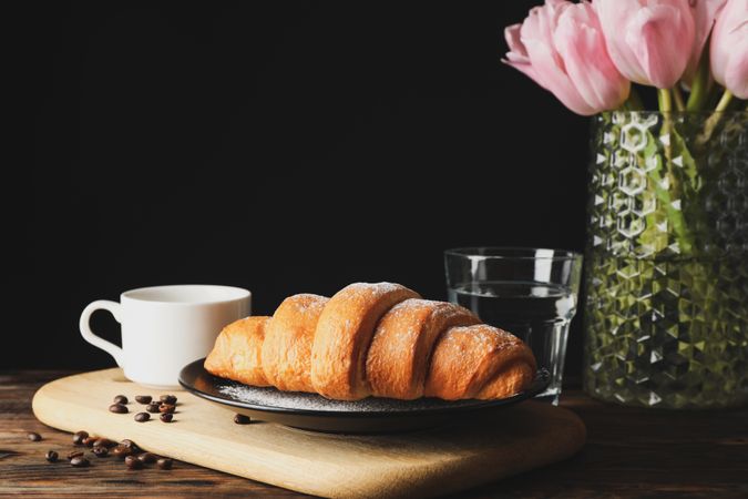 Banner with croissants on wooden breadboard, with vase and space for text