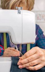 Mature seamstress woman working on sewing machine